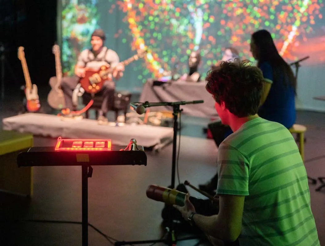 Audience members playing at an instrument station.